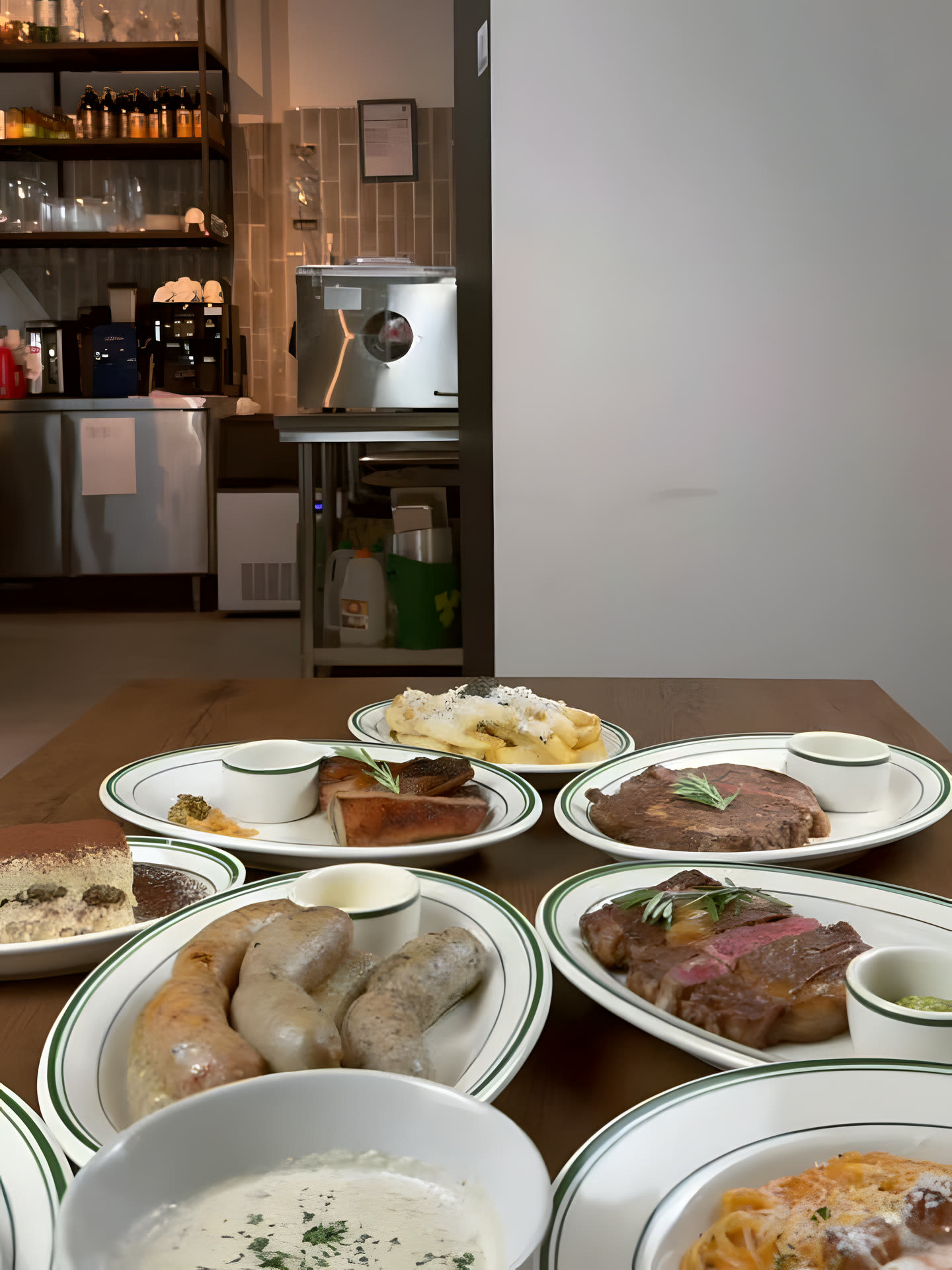 A full table of grilled meats, sausages and tiramisu at Dilly Deli