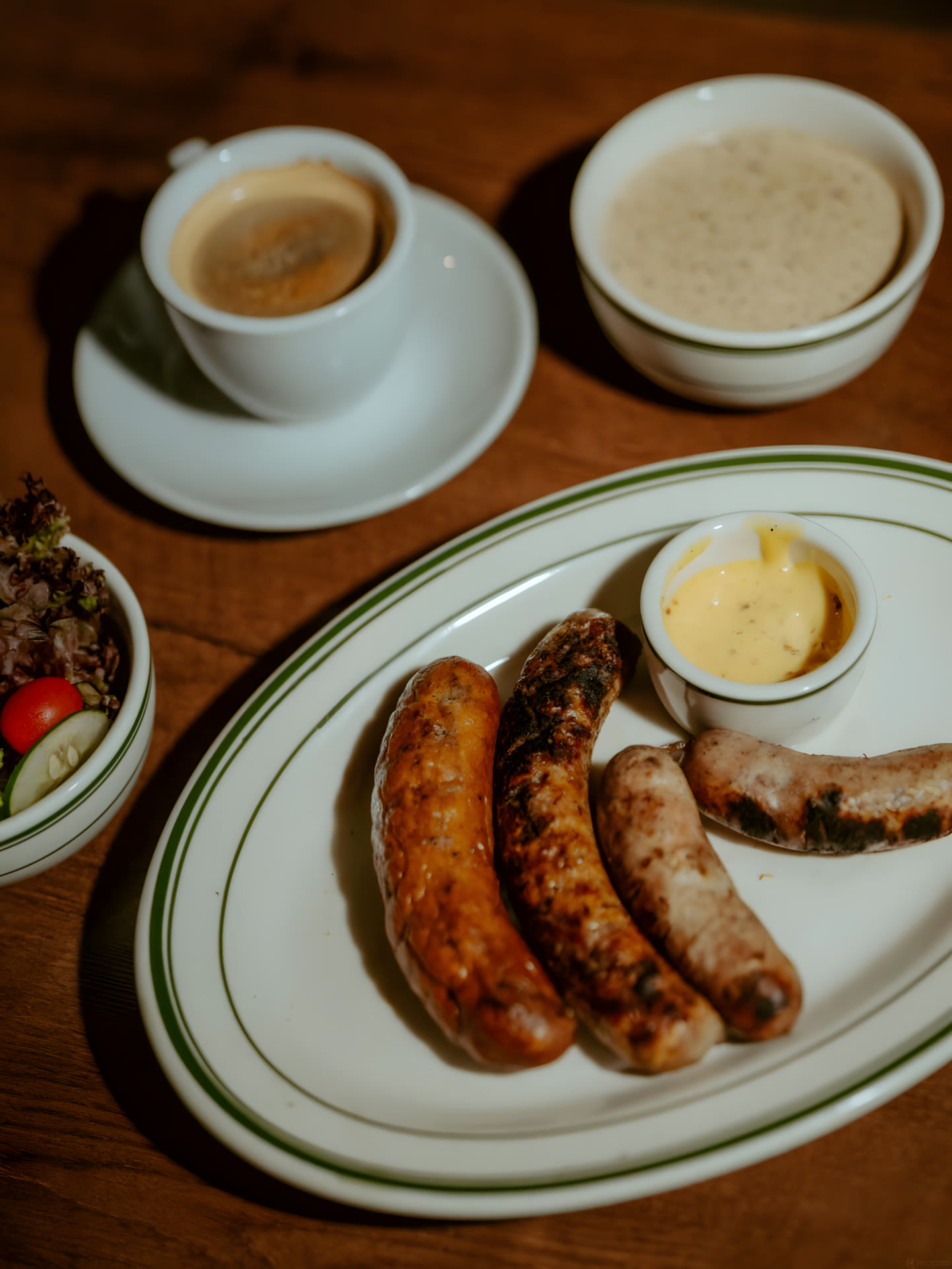 Handmade sausages with mustard on a green-rim plate